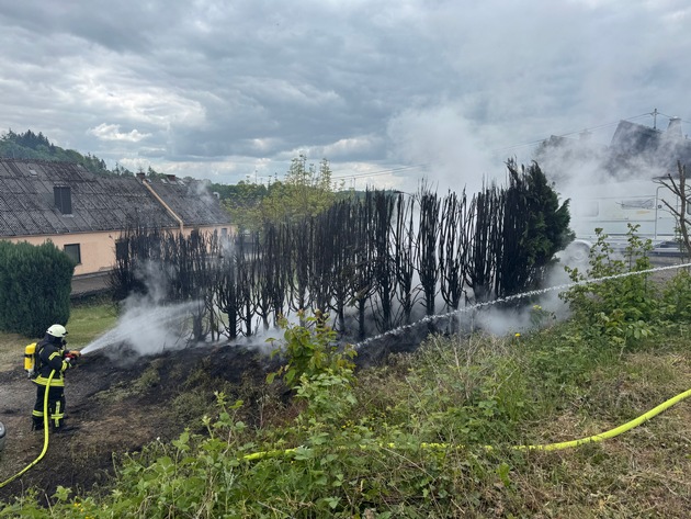 FW VG Westerburg: Tujahecke steht in Flammen - Rauchsäule von weitem sichtbar