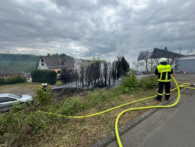 FW VG Westerburg: Tujahecke steht in Flammen - Rauchsäule von weitem sichtbar