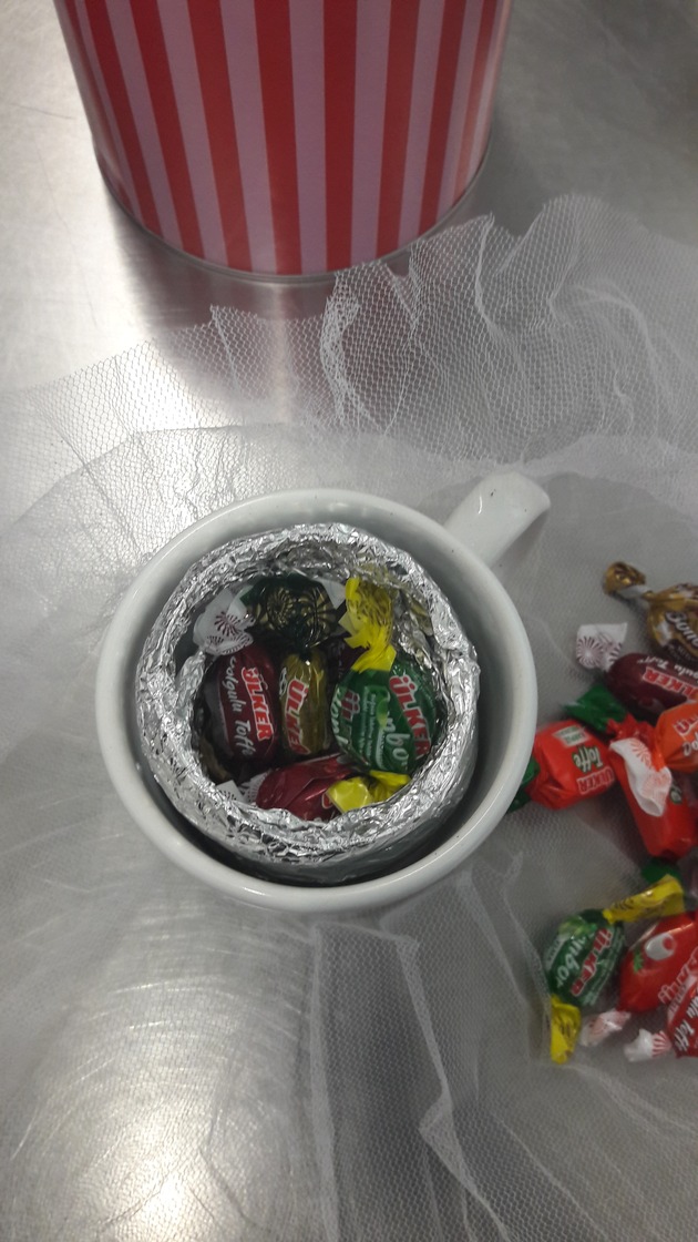 HZA-S: süß und goldig Frau versucht Goldschmuck in einer Tasse mit Süßigkeiten zu schmuggeln