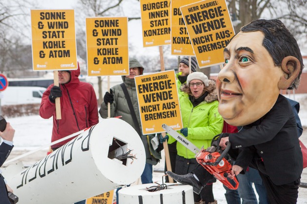 Protest gegen &quot;Gabriel-Bremse&quot; für Erneuerbare Energien / Protestaktion von BUND und Campact vor Schloss Meseberg: Person mit Gabriel-Maske sägt an Windrad (FOTO)