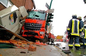 Feuerwehr Essen: FW-E: LKW gegen Ampelmast und Fassade gerollt, erste Meldung: Fahrer eingeklemmt