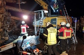 Feuerwehr Plettenberg: FW-PL: Baumstamm durchspießt bei Holzverladearbeiten das Fahrerhaus eines Baggers. Fahrzeugführer eingeklemmt.