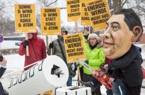 Campact e.V.: Protest gegen "Gabriel-Bremse" für Erneuerbare Energien / Protestaktion von BUND und Campact vor Schloss Meseberg: Person mit Gabriel-Maske sägt an Windrad