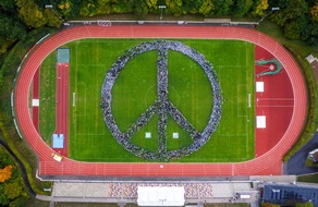 REKORD-INSTITUT für DEUTSCHLAND: »augen auf! für menden« bildet größtes Peace-Zeichen aus Menschen und holt mit 4.172 Personen den RID-Weltrekord