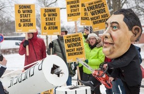 Campact e.V.: Protest gegen "Gabriel-Bremse" für Erneuerbare Energien / Protestaktion von BUND und Campact vor Schloss Meseberg: Person mit Gabriel-Maske sägt an Windrad (FOTO)