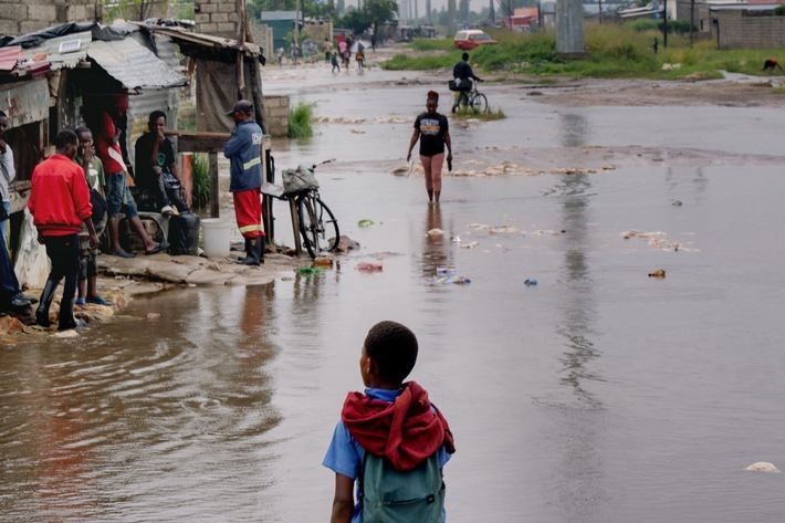 Menschen in überfluteten Gebieten Ende 2025, die durch das Hochwasser gehen oder vor Wellblechhütten stehen. (Bild nur zur Verwendung im Kontext der SOS-Kinderdörfer weltweit) / Weiterer Text über ots und www.presseportal.de/nr/1658 / Die Verwendung dieses Bildes für redaktionelle Zwecke ist unter Beachtung aller mitgeteilten Nutzungsbedingungen zulässig und dann auch honorarfrei. Veröffentlichung ausschließlich mit Bildrechte-Hinweis.