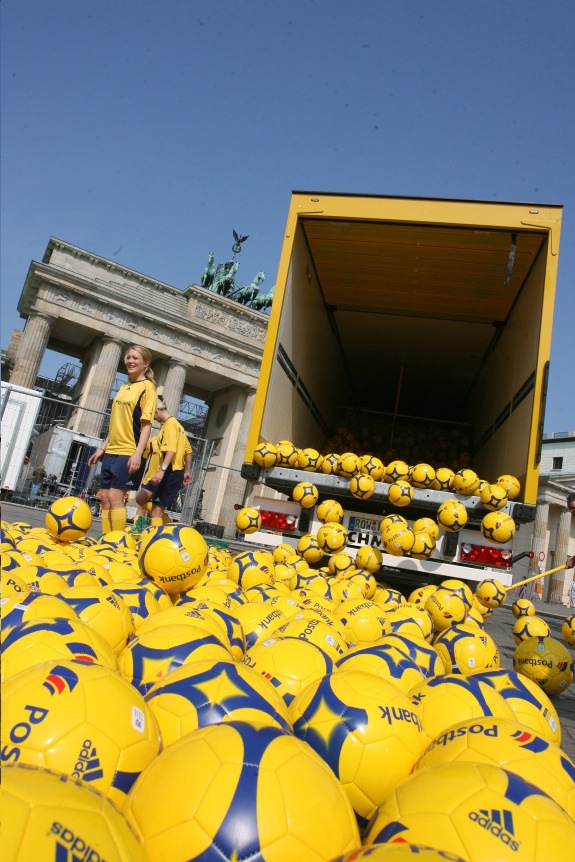 Postbank: Fünftausend Bälle für Berlin / Dankeschön-Aktion für die Berliner Fußball-Fans / Postbank verschenkt 5.000 gelbe Fußbälle vor dem Brandenburger Tor