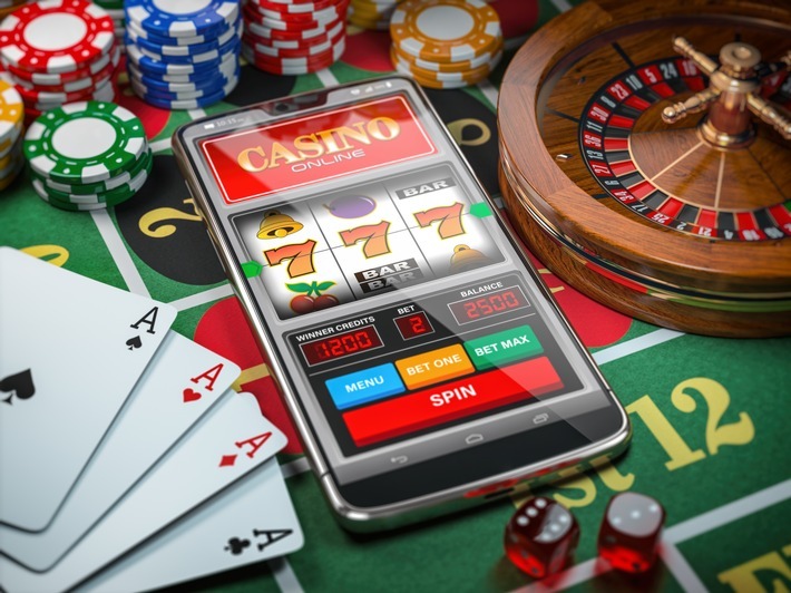 Casino online. Smartphone or mobile phone, slot machine, dice, cards and roulette on a green table in casino. 3d illustration / Weiterer Text über ots und www.presseportal.de/nr/165081 / Die Verwendung dieses Bildes ist für redaktionelle Zwecke unter Beachtung ggf. genannter Nutzungsbedingungen honorarfrei. Veröffentlichung bitte mit Bildrechte-Hinweis.