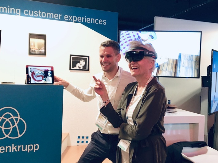 Greta Silver, Autorin, Speakerin und YouTuberin (rechts), hat thyssenkrupp am Stand beim Digital Kindergarten besucht und sich die HoloLinc-Technologie von Projektleiter Simon Feismann (links) vorstellen lassen. Das Ergebnis: pure Begeisterung. Revolutionäre HoloLinc-Technologie beim Digital Kindergarten 2019: thyssenkrupp Elevator präsentierte weltweit erste Industrie-4.0-Lösung für Treppenliftproduktion im Hamburger Millerntor-Stadion. Weiterer Text über ots und www.presseportal.de/nr/113002 / Die Verwendung dieses Bildes ist für redaktionelle Zwecke honorarfrei. Veröffentlichung bitte unter Quellenangabe: "obs/thyssenkrupp elevator AG"