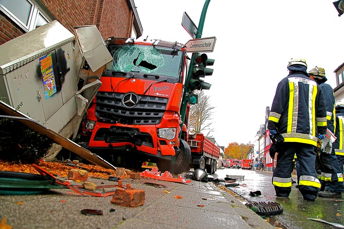 FW-E: LKW gegen Ampelmast und Fassade gerollt, erste Meldung: Fahrer eingeklemmt