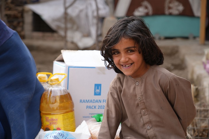 Ein Kind in Afghanistan freut sich über das Lebensmittelpaket zu Ramadan_Copyright Islamic Relie.jpg