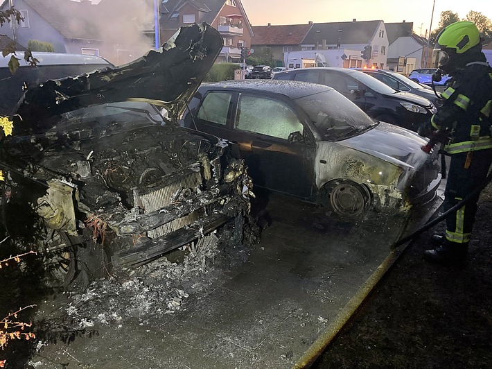FW Bergheim: Feuerwehr löscht brennende Fahrzeuge in Bergheim Zwei PKW brannten auf Parkplatz - Auch angrenzende Hecke betroffen