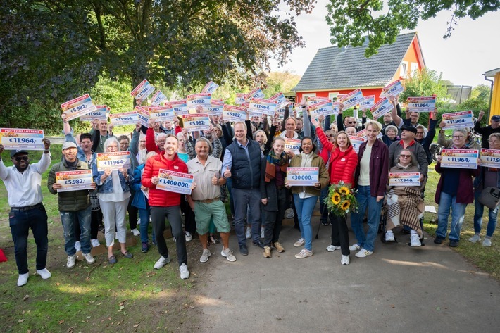 88 Grundhofer Gewinner*innen feiern zusammen mit dem Verein "Transformationszentrum Flensburg e.V.", Bürgermeister Bernd Wunder, dem Landtagsabgeordneten Thomas Jepsen und den Glücksboten Beatrice Maria Frensel und Felix Uhlig. / Weiterer Text über ots und www.presseportal.de/nr/41583 / Die Verwendung dieses Bildes für redaktionelle Zwecke ist unter Beachtung aller mitgeteilten Nutzungsbedingungen zulässig und dann auch honorarfrei. Veröffentlichung ausschließlich mit Bildrechte-Hinweis.