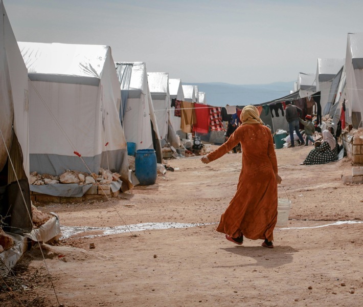 Eine syrische Frau läuft durch ein Flüchtlingslager. Syrien ist nach wie vor das Land mit den meisten Vertriebenen insgesamt: 13,8 Millionen Menschen sind inzwischen gewaltsam vertrieben worden. / Weiterer Text über ots und www.presseportal.de/nr/50131 / Die Verwendung dieses Bildes für redaktionelle Zwecke ist unter Beachtung aller mitgeteilten Nutzungsbedingungen zulässig und dann auch honorarfrei. Veröffentlichung ausschließlich mit Bildrechte-Hinweis.