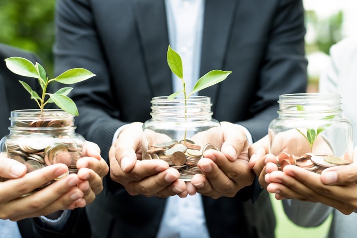 Business people holding glass jars with plants growing from money - investment and financial metaphor / TARGOBANK kooperiert mit Amundi Deutschland GmbH und erweitert Angebot an nachhaltigen Investment-Produkten / Weiterer Text über ots und www.presseportal.de/nr/78980 / Die Verwendung dieses Bildes ist für redaktionelle Zwecke honorarfrei. Veröffentlichung bitte unter Quellenangabe: "obs/TARGOBANK AG/©kritchanut - stock.adobe.com"