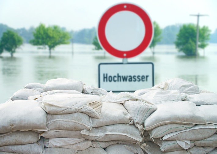 Hochwasserschild vor Sandsäcken_PhotographyByMK_AdobeStock_53554413.jpeg