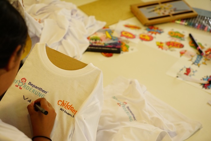 Kinder und Jugendliche von CHILDREN FOR A BETTER WORLD e.V. gestalten T-Shirts und Armbänder mit Komplimenten für andere Kinder und Jugendliche im Rahmen des Förderprogramms "Komplimente-Schmiede" von der Bepanthen®-Kinderförderung. / Weiterer Text über ots und www.presseportal.de/nr/113164 / Die Verwendung dieses Bildes für redaktionelle Zwecke ist unter Beachtung aller mitgeteilten Nutzungsbedingungen zulässig und dann auch honorarfrei. Veröffentlichung ausschließlich mit Bildrechte-Hinweis.