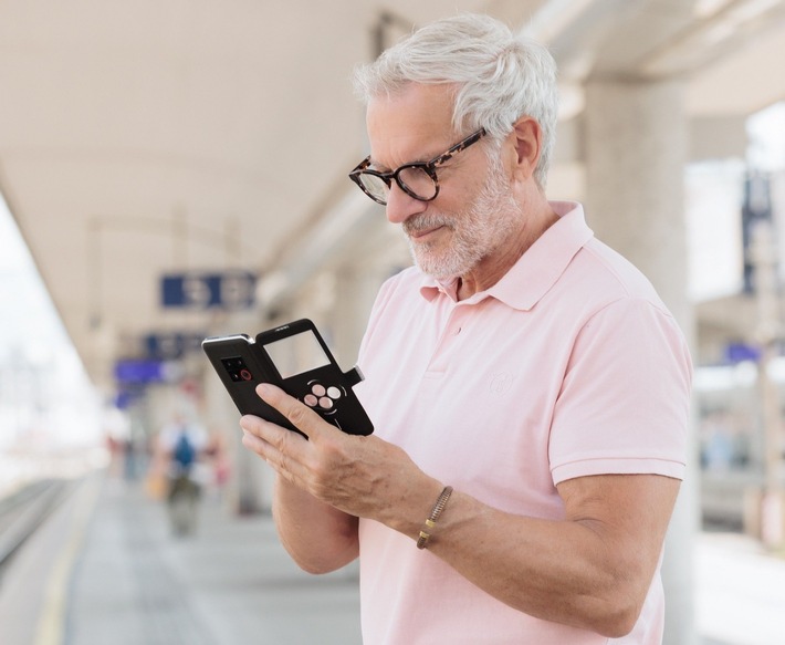 Mann am Bahnsteig mit dem Smartphone emporiaSMART.8