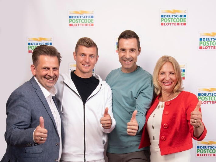 Toni Kroos wird internationaler Botschafter der Deutschen Postcode Lotterie / Toni Kroos wird neuer Botschafter der Deutschen Postcode Lotterie: Die Geschäftsführung der Soziallotterie, Annemiek Hoogenboom (rechts) und Sascha Maas (links), freut sich gemeinsam mit Botschafter Kai Pflaume (Mitte rechts) über den Neuzugang. Weiterer Text über ots und www.presseportal.de/nr/41583 / Die Verwendung dieses Bildes ist für redaktionelle Zwecke honorarfrei. Veröffentlichung bitte unter Quellenangabe: "obs/Deutsche Postcode Lotterie/Paul Schirnhofer"