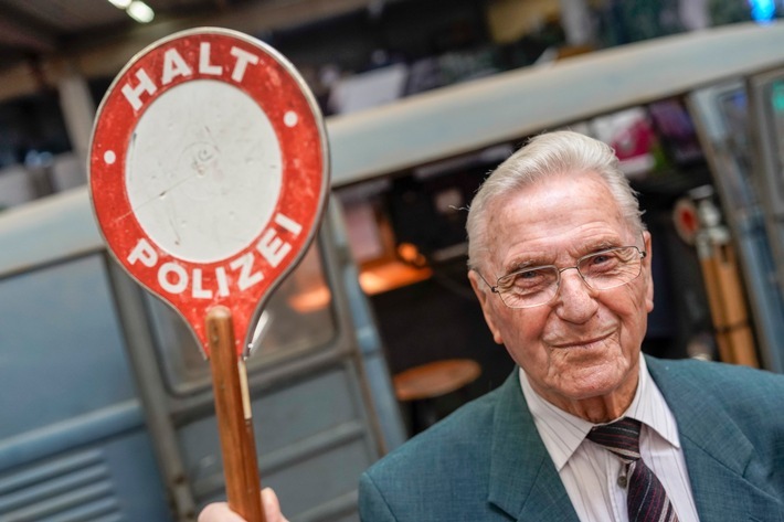 Halt, Polizei! Der ehemalige Polizeihauptwachtmeister Heinz Scholze (89) hebt die Polizeikelle, im Hintergrund der alte Blitzer-Bulli. Weiterer Text über ots und www.presseportal.de/nr/55462 / Die Verwendung dieses Bildes ist für redaktionelle Zwecke honorarfrei. Veröffentlichung bitte unter Quellenangabe: "obs/VW Volkswagen Nutzfahrzeuge AG/Volkswagen Nutzfahrzeuge"
