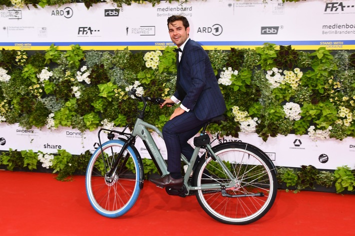 Lucas Reiber, Nachhaltigkeitsbotschafter des Deutschen Filmpreises, kam mit vielen Schauspielkolleg:innen mit Fahrrad statt Limousine  zur Preisverleihung / Foto: Swapfiets/AEDT