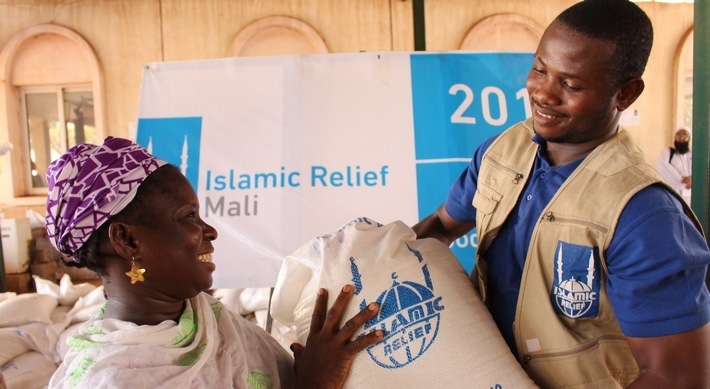 Ein Sozialarbeiter von Islamic Relief übergibt der alleinerziehenden Nango in Mali ihr Lebensmittelpaket. Weiterer Text über ots und www.presseportal.de/nr/50131 / Die Verwendung dieses Bildes ist für redaktionelle Zwecke honorarfrei. Veröffentlichung bitte unter Quellenangabe: "obs/Islamic Relief Deutschland e.V./M. GOITA/Islamic Relief"