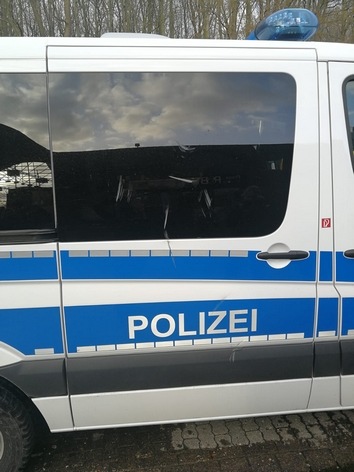 BPOL-FL: Mann bewirft Polizeifahrzeug mit Absperrbarke