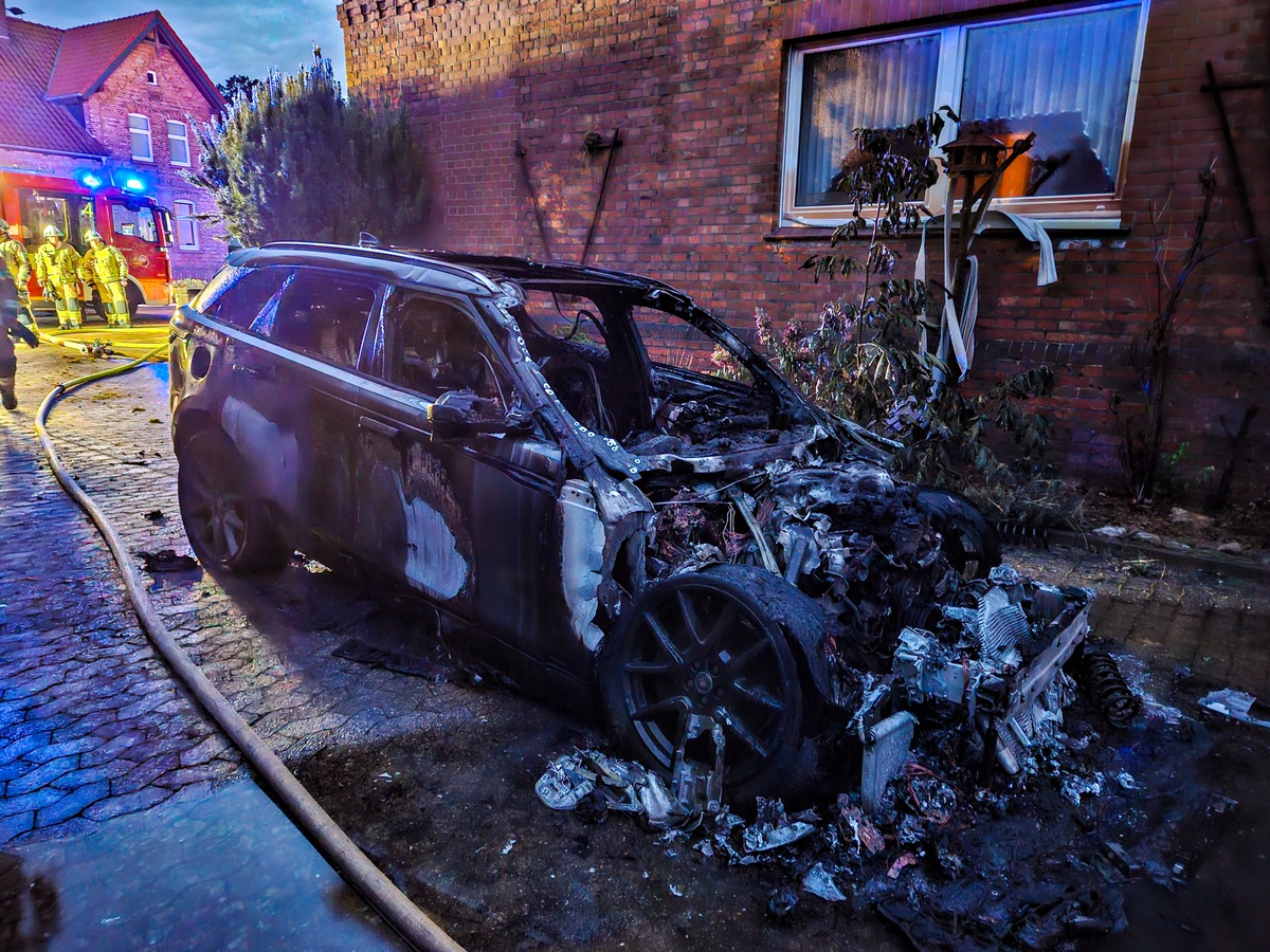 FW Lehrte: Hybrid-SUV in Vollbrand - ehrenamtliche Einsatzkräfte verhindern schlimmeres und schützen Haus vor den Flammen.