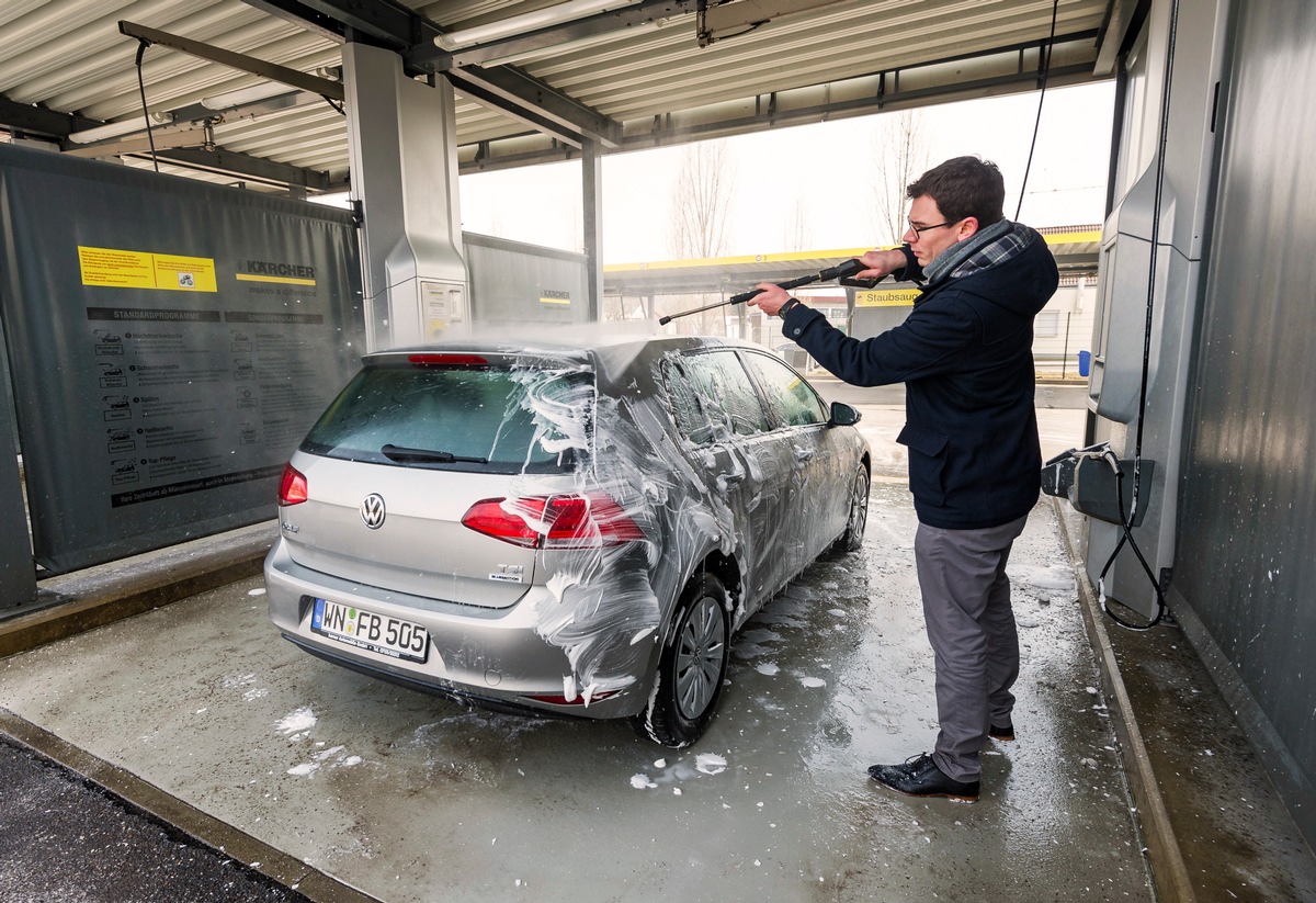Der mann wischt die amerikanische suv-autohaube nach dem waschen