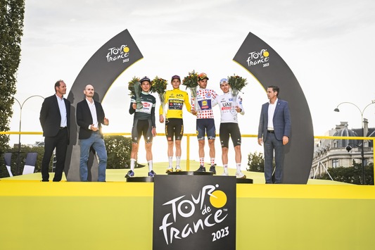 Tour de France-Sieger rollt in Begleitung des noch getarnten Škoda Superb Combi ins Ziel und erhält von Škoda Design entworfene Trophäe
